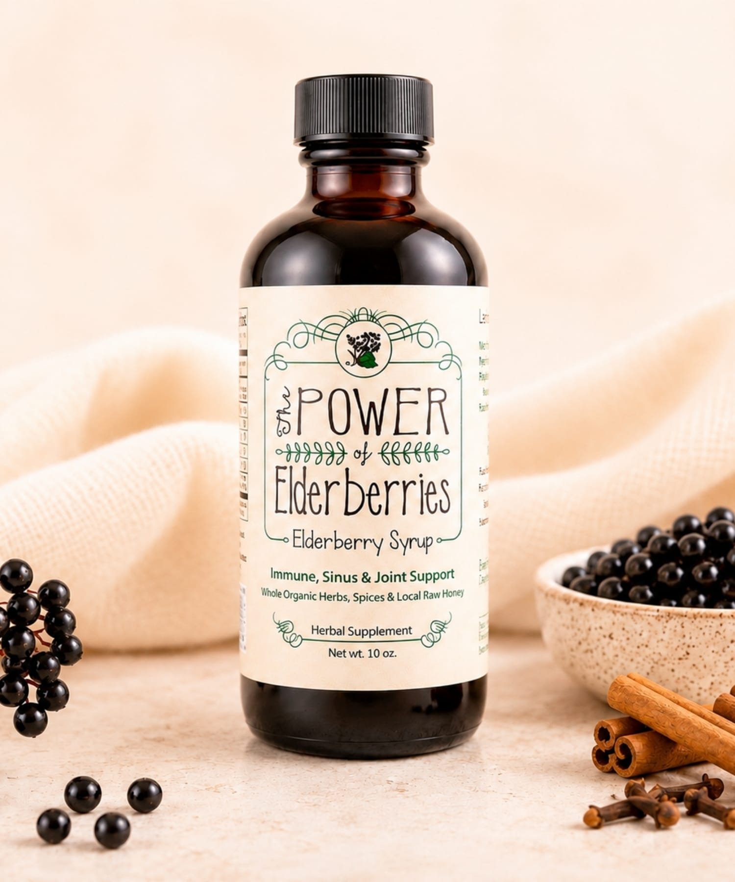 10oz elderberry syrup with organic elderberries, cinnamon sticks, whole cloves on a countertop.