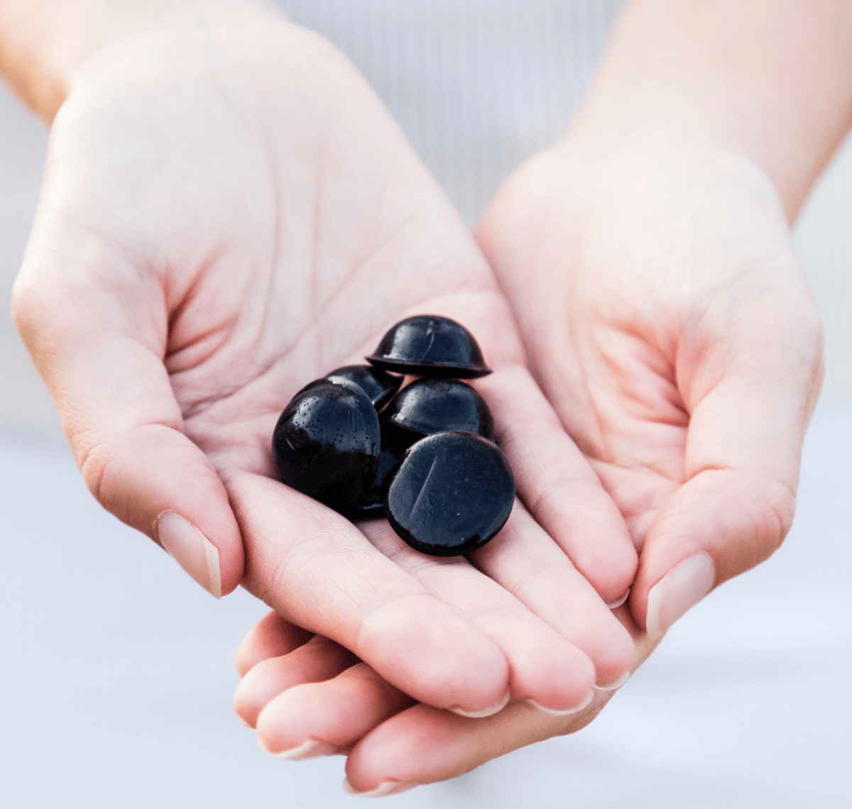 A picture of The POWER of Elderberries Signature Elderberry Syrup Bites being held in a females hands.