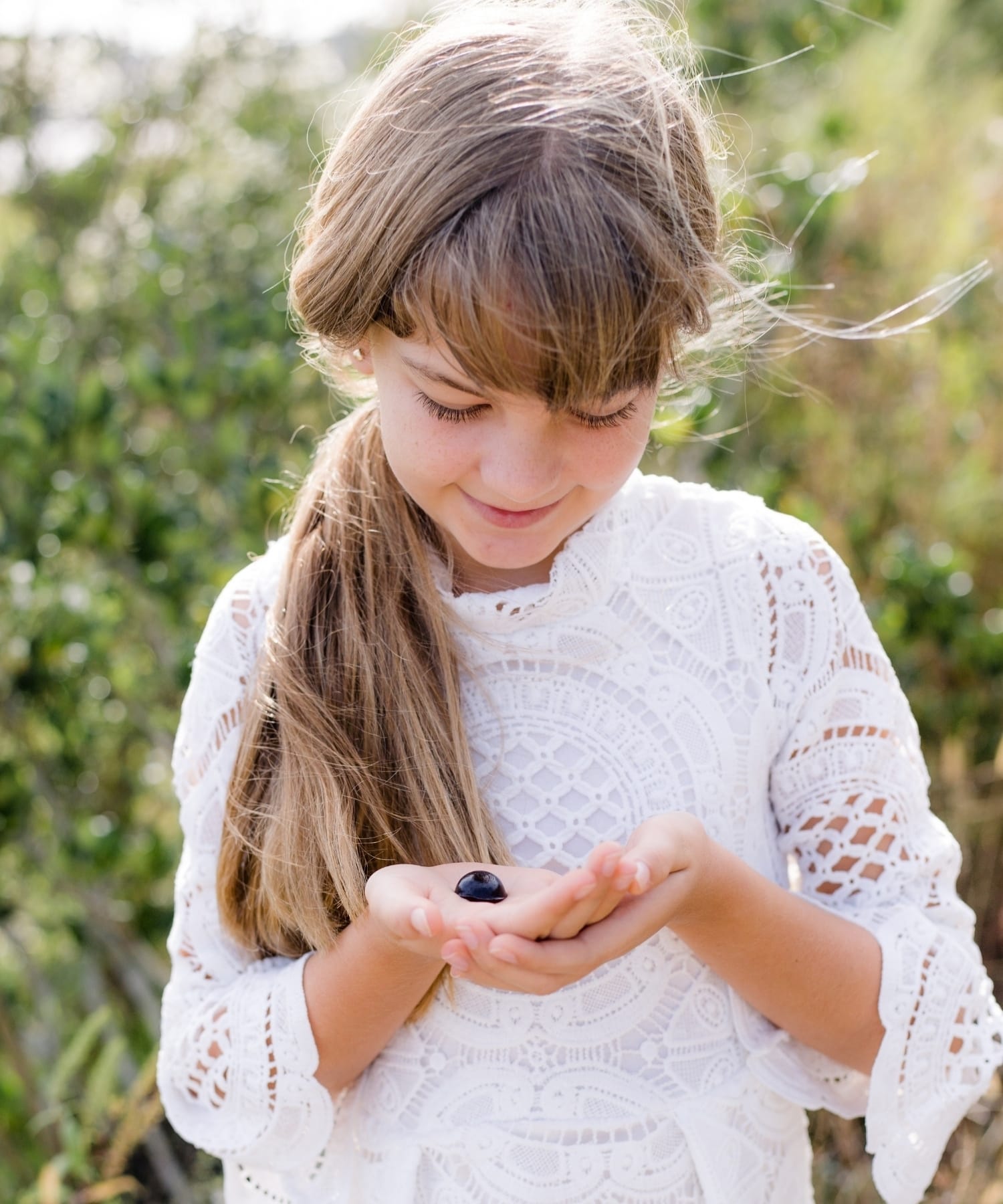 A daughter holding an elderberry syrup bite in the palm of her hands.
