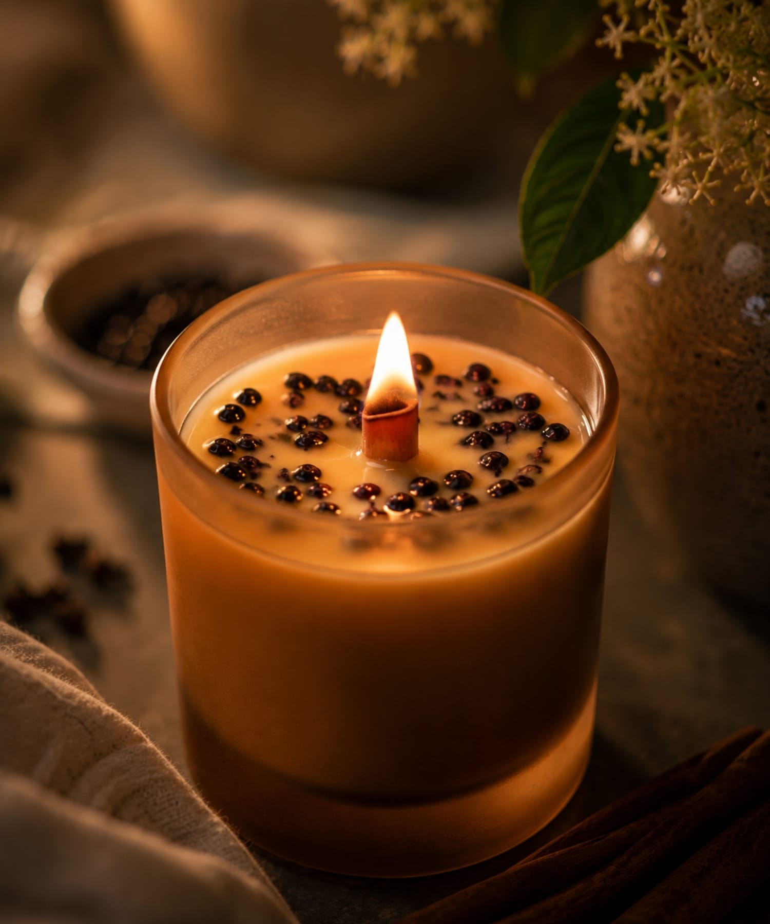 Close-up of Signature Elderberry Beeswax Candle with wooden wick and soft warm glow.