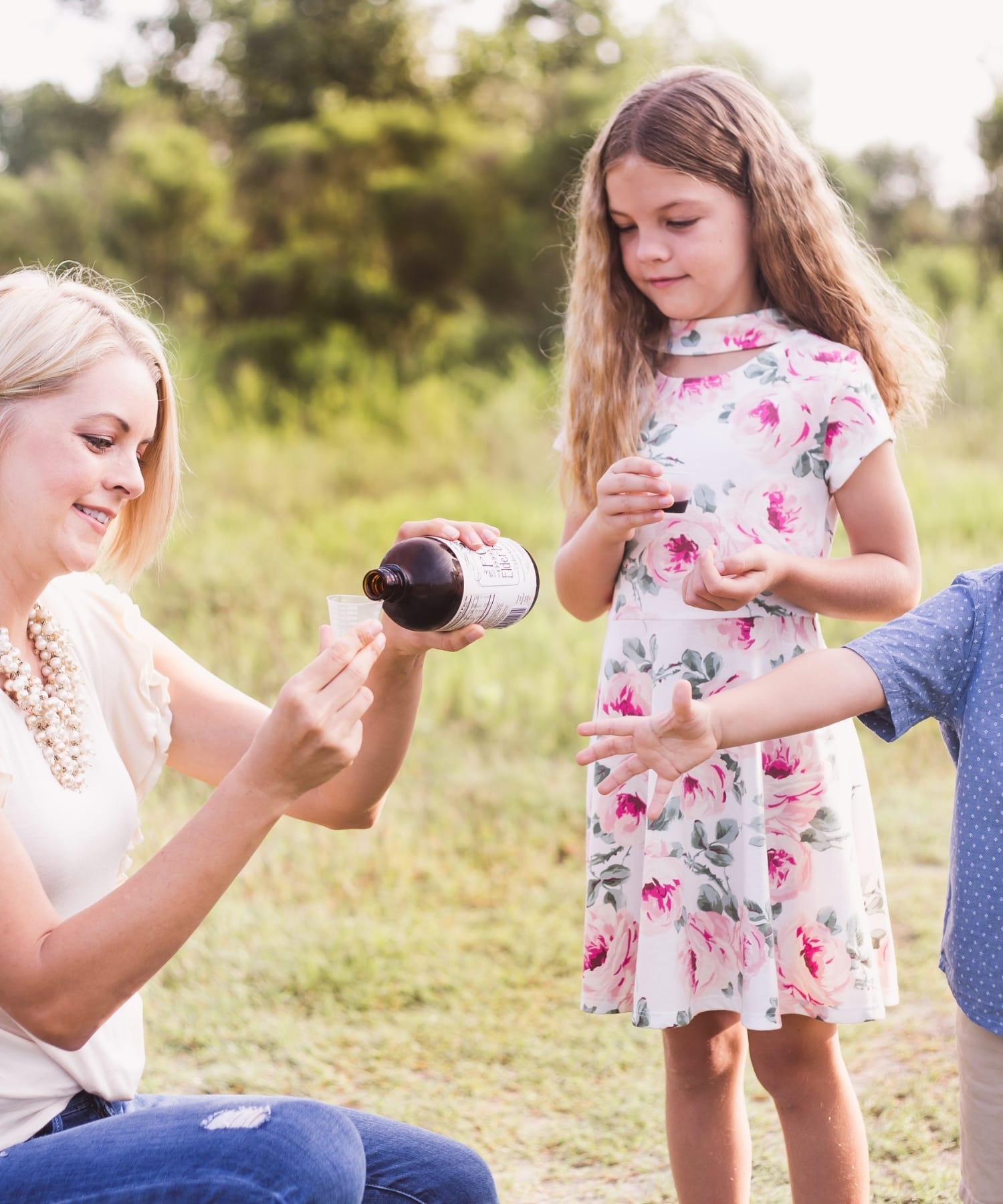 The founder of The POWER of Elderberries pouring elderberry syrup for her kids.