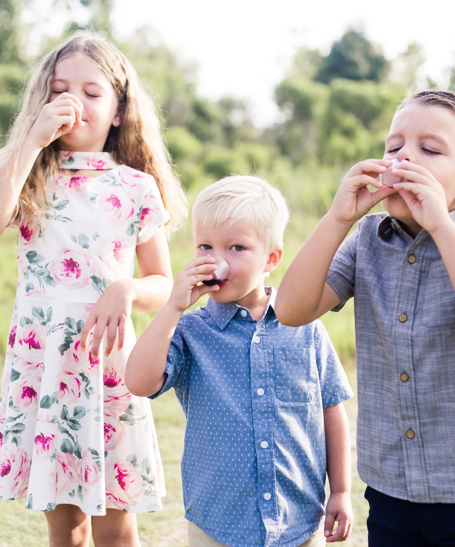 Three kids drinking delicious elderberry syrup.