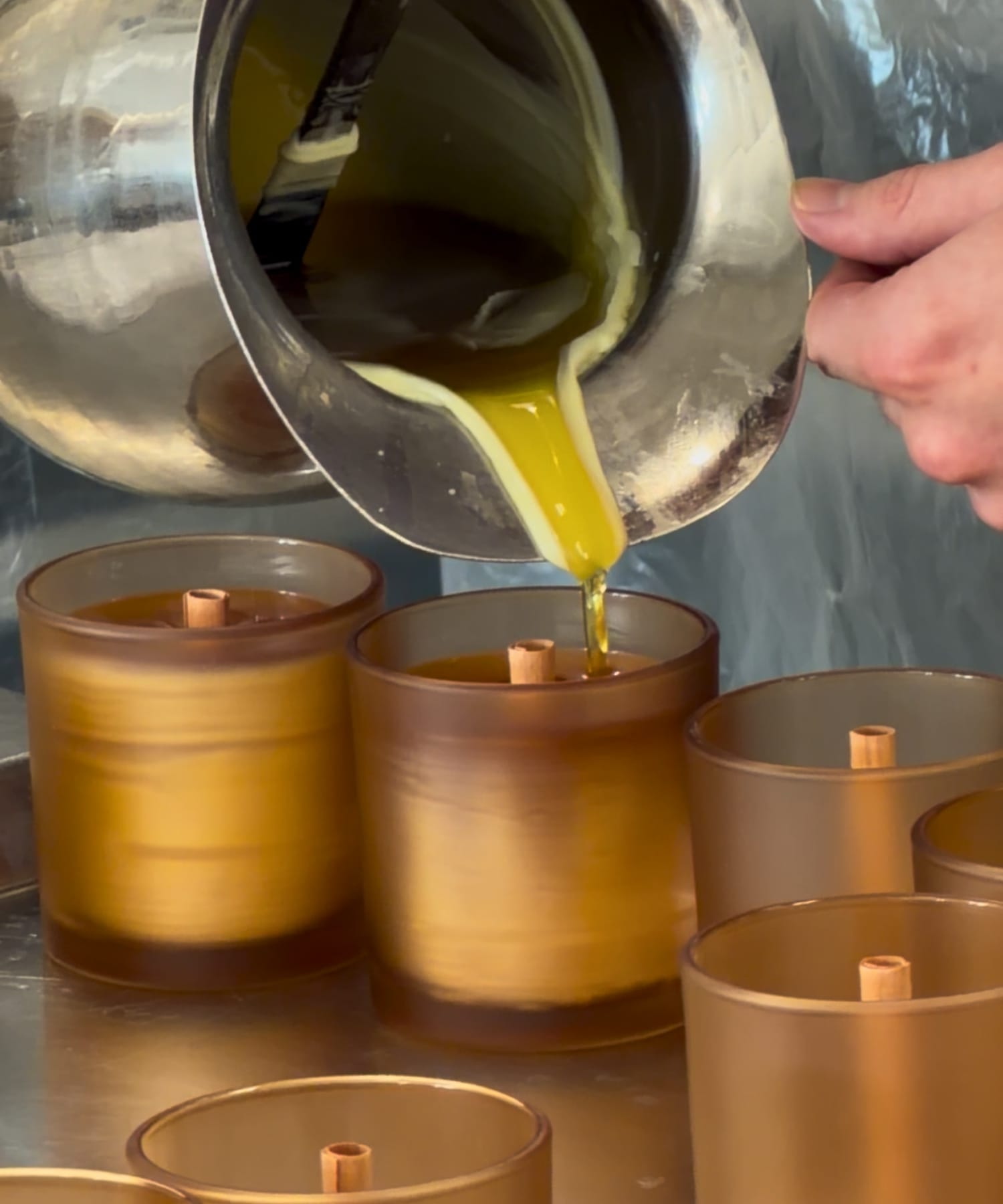 Hand-pouring Signature Elderberry Beeswax Candles in small handcrafted batches.